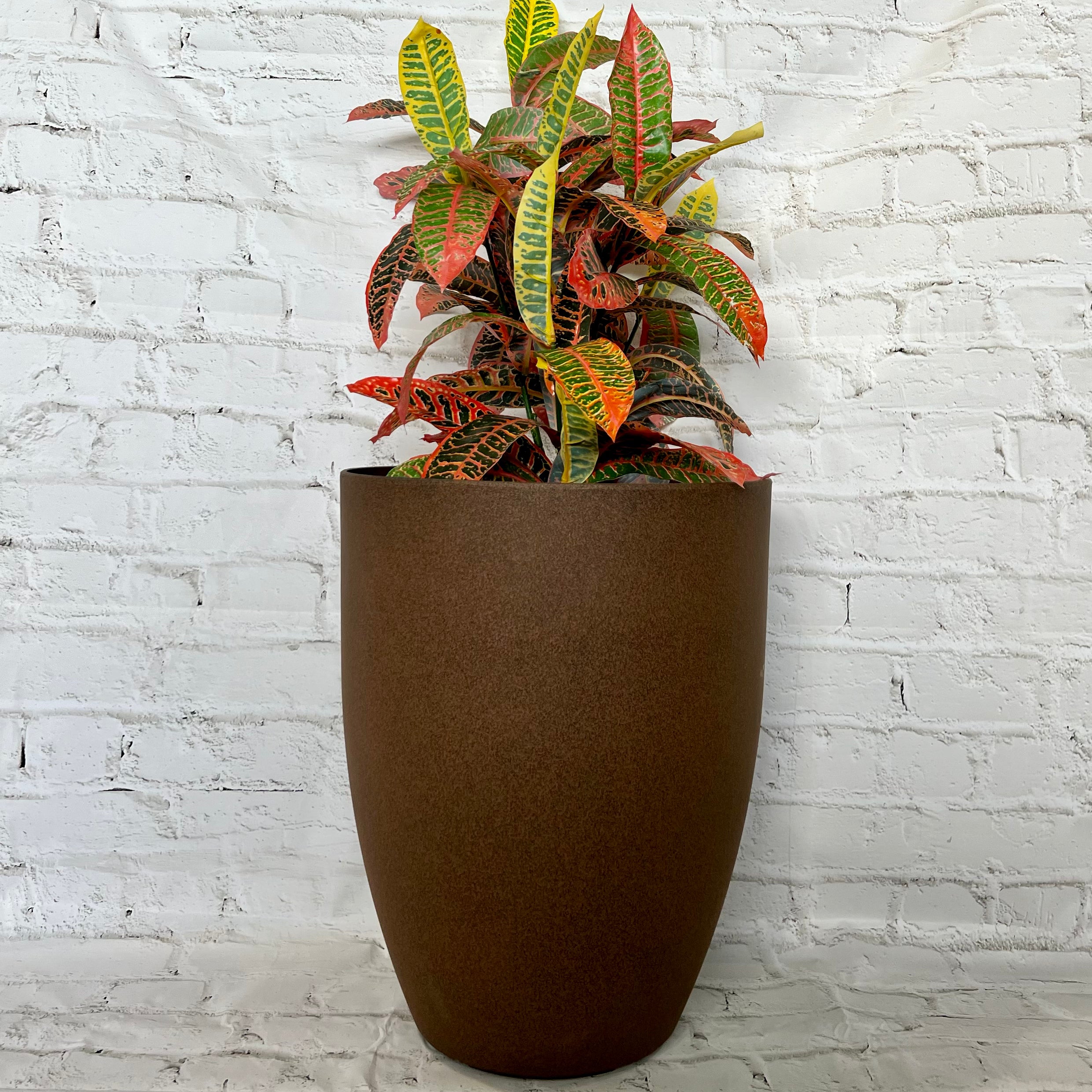 Adam Pot lifestyle - round tapered composite pot in garden